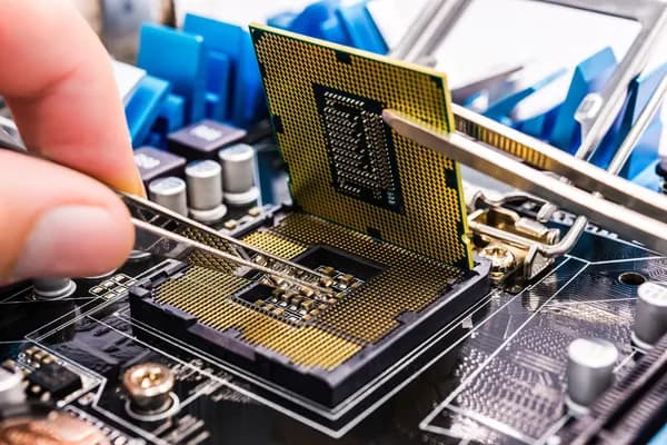 Technician inspecting a desktop motherboard near the CPU socket