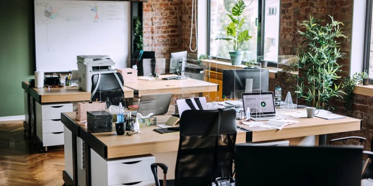 Office desks with computers and a shared printer
