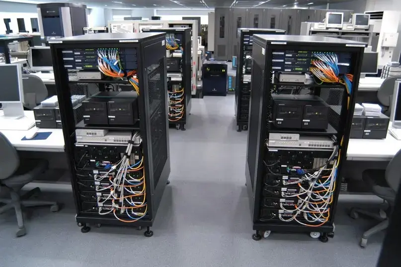 Business workstations, equipment racks, and network cabling being prepared for setup