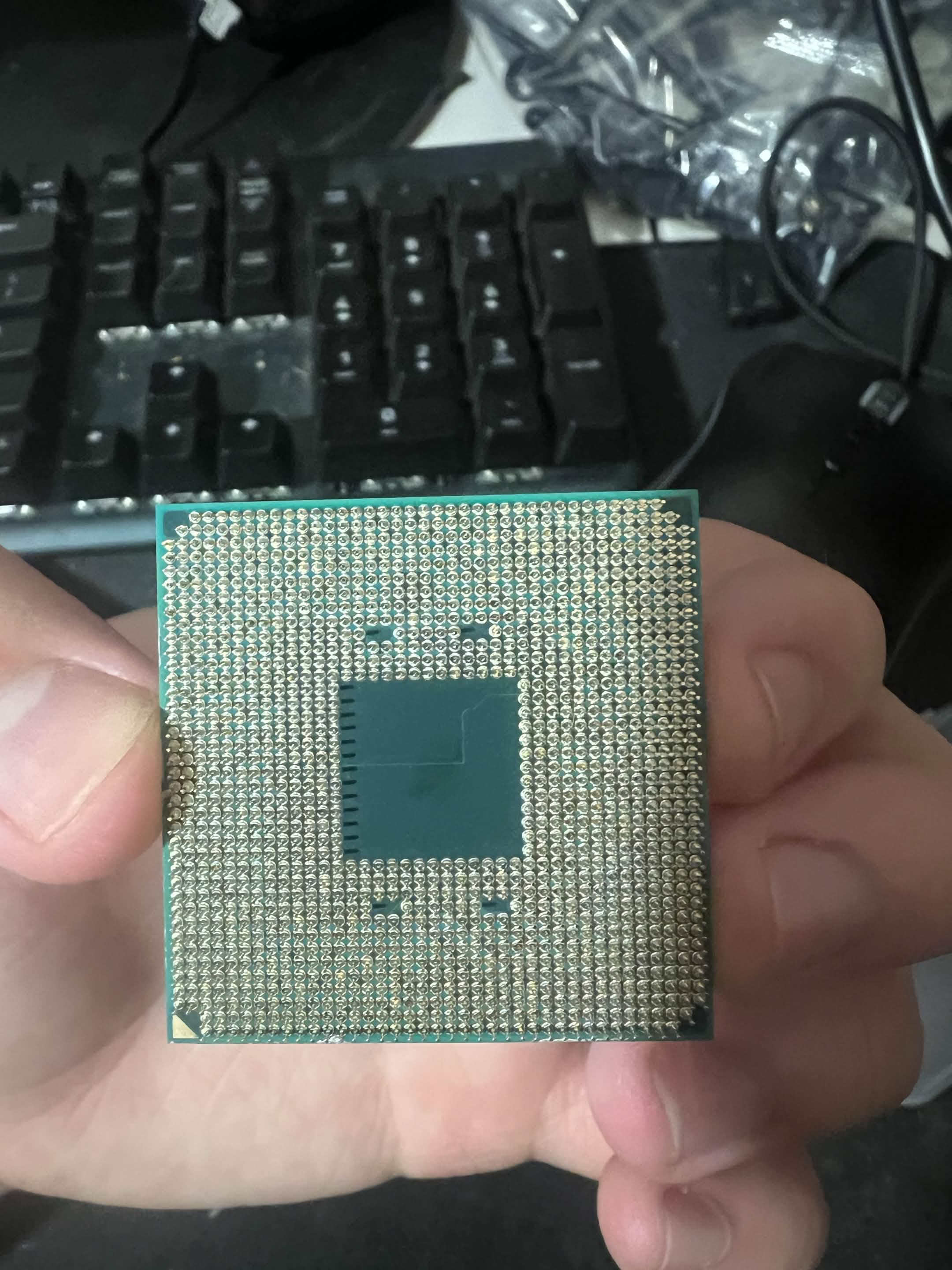 Underside of a desktop processor held for inspection during diagnosis