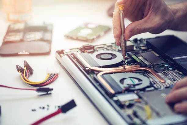 Technician working inside an open laptop during a hardware repair